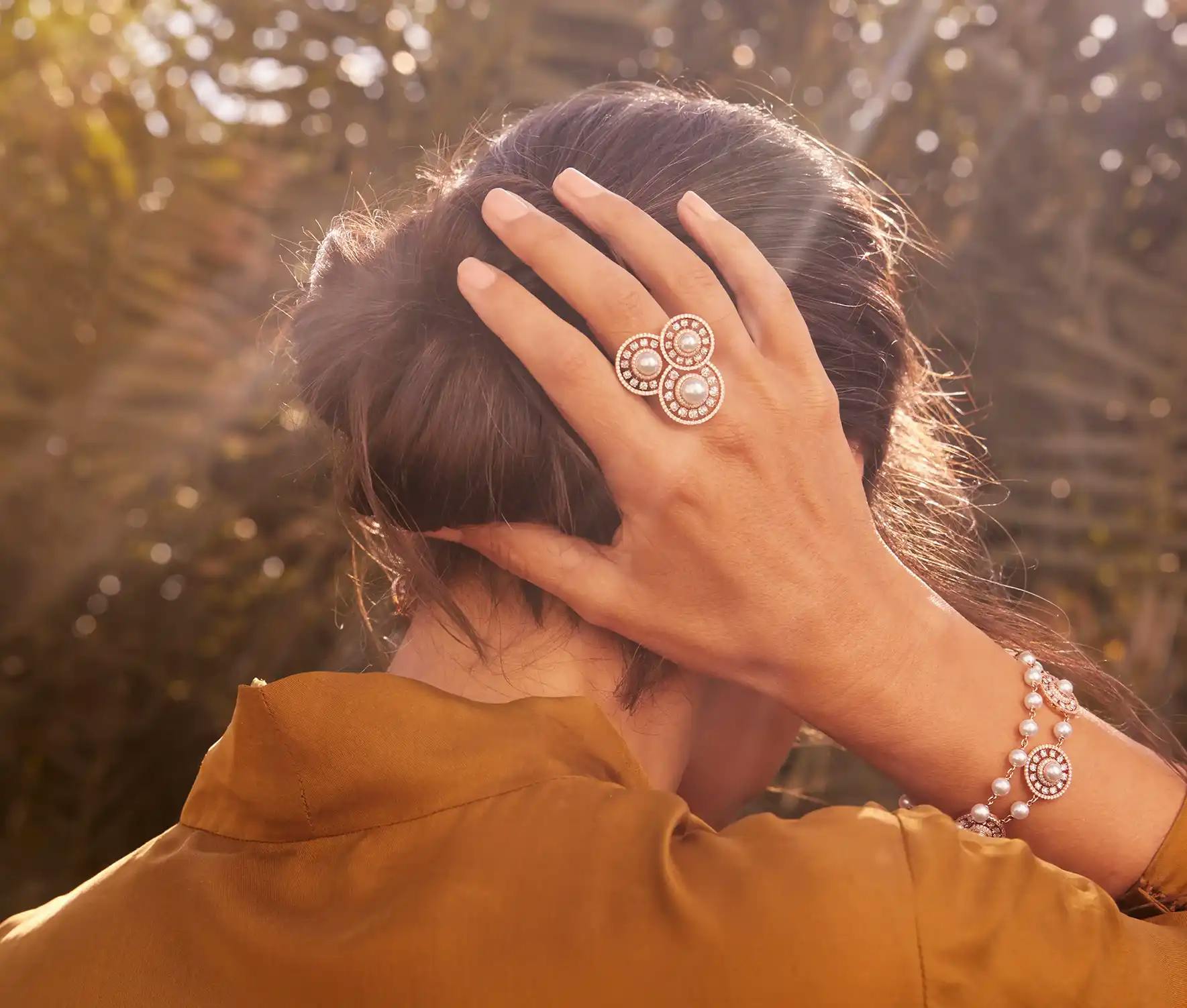 Woman wearing 18K recycled rose gold ring and bracelet fitted with rose-cut diamonds, Akoya pearls, pavé diamonds.